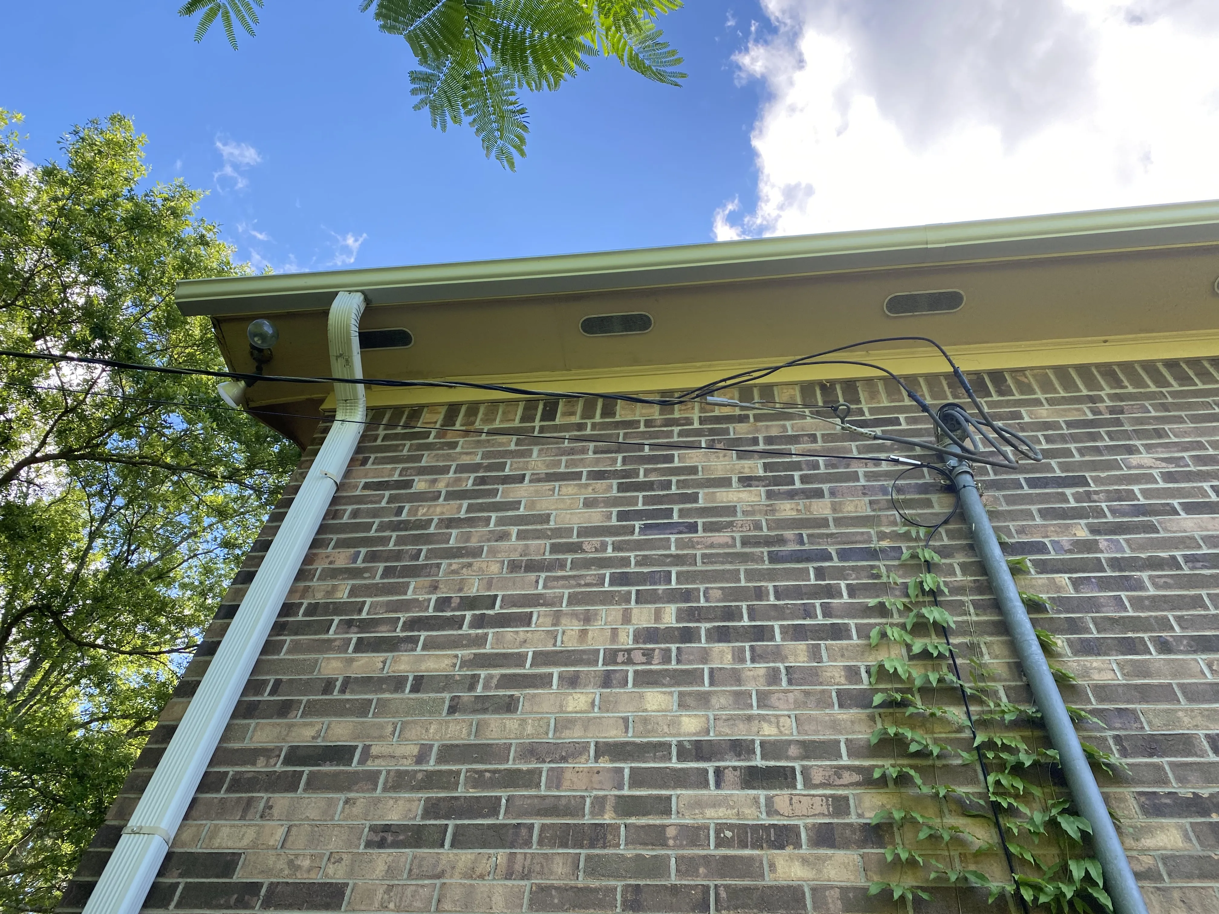 Gutter and downspout repair on the exterior of a brick home in Pontotoc