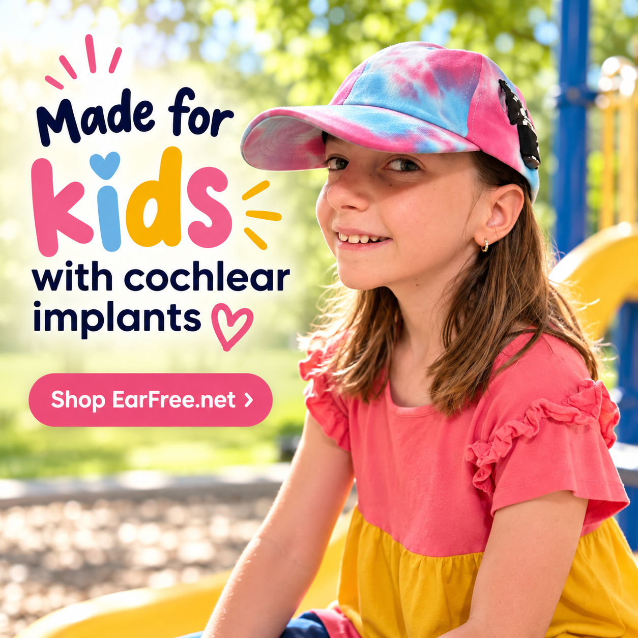 Little girl wearing a pink-and-blue tie-dye EarFree hat with her cochlear implant processor visible. Made for kids with cochlear implants.