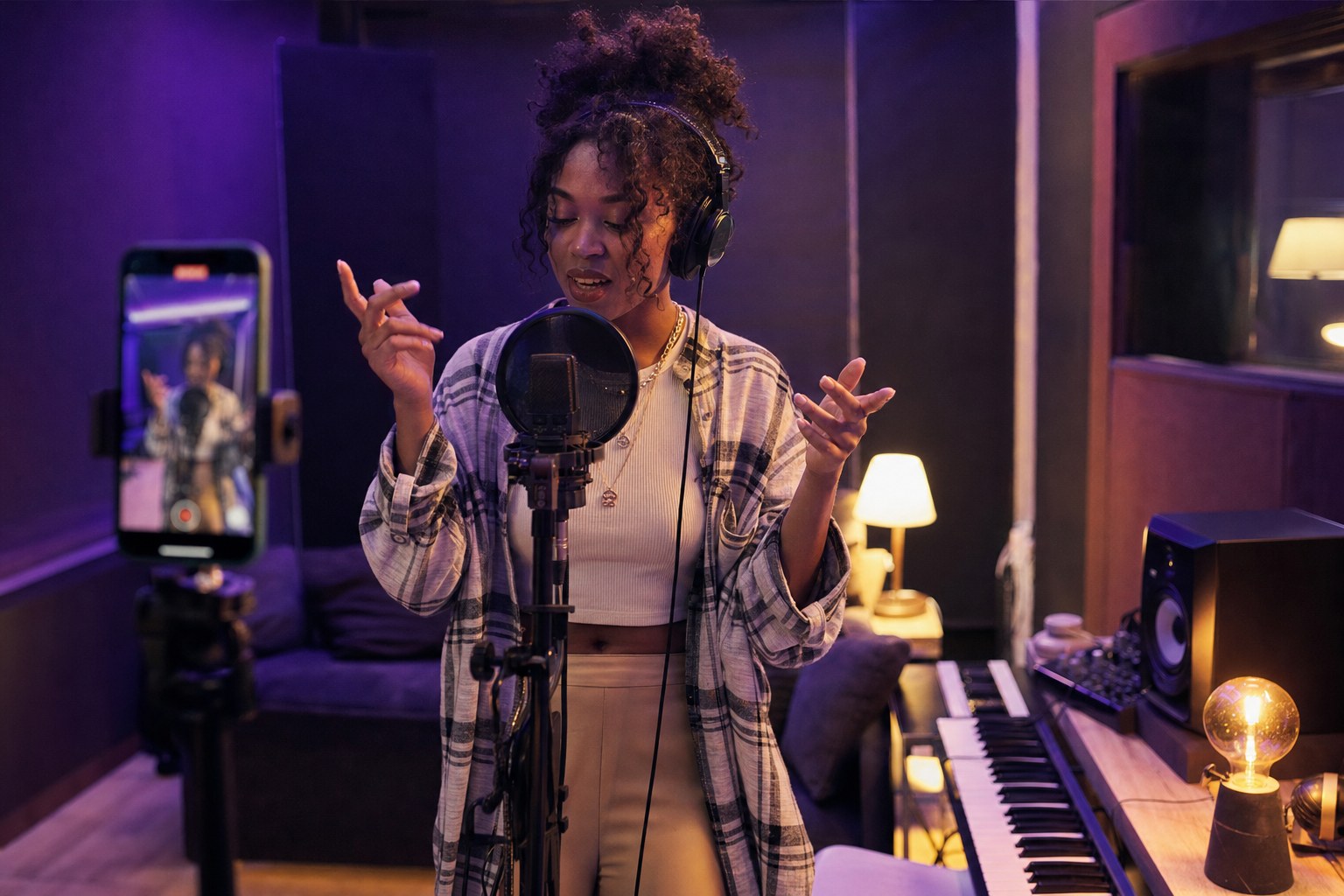 Independent artist filming a vertical performance video in a recording studio
