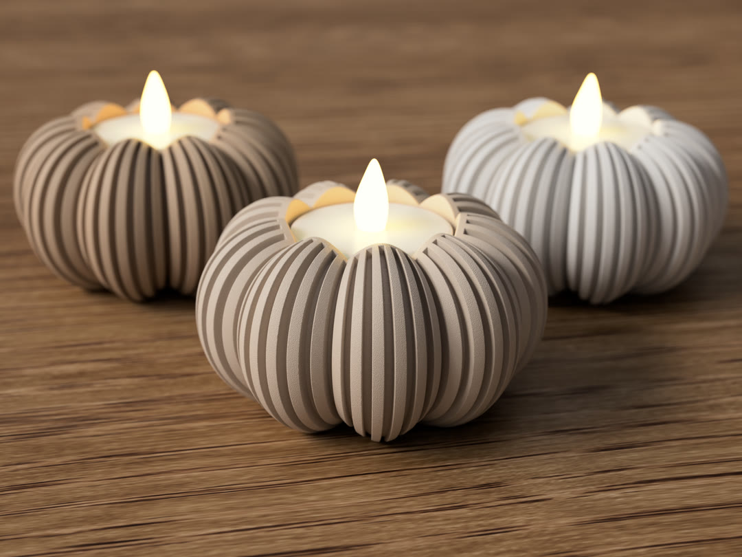 Three ribbed tea light holders with warm glowing candles