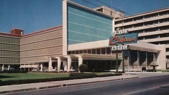 Exterior view of the Atlanta Cabana Motel, featuring modern architecture, a large turquoise facade, and a prominent vintage sign.