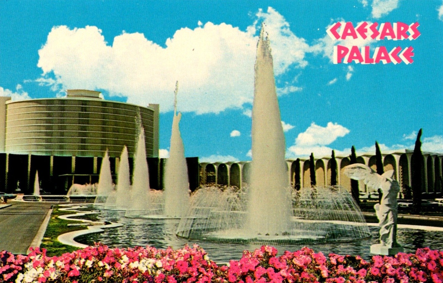 Postcard of Caesars Palace featuring fountains and floral landscaping under a blue sky.