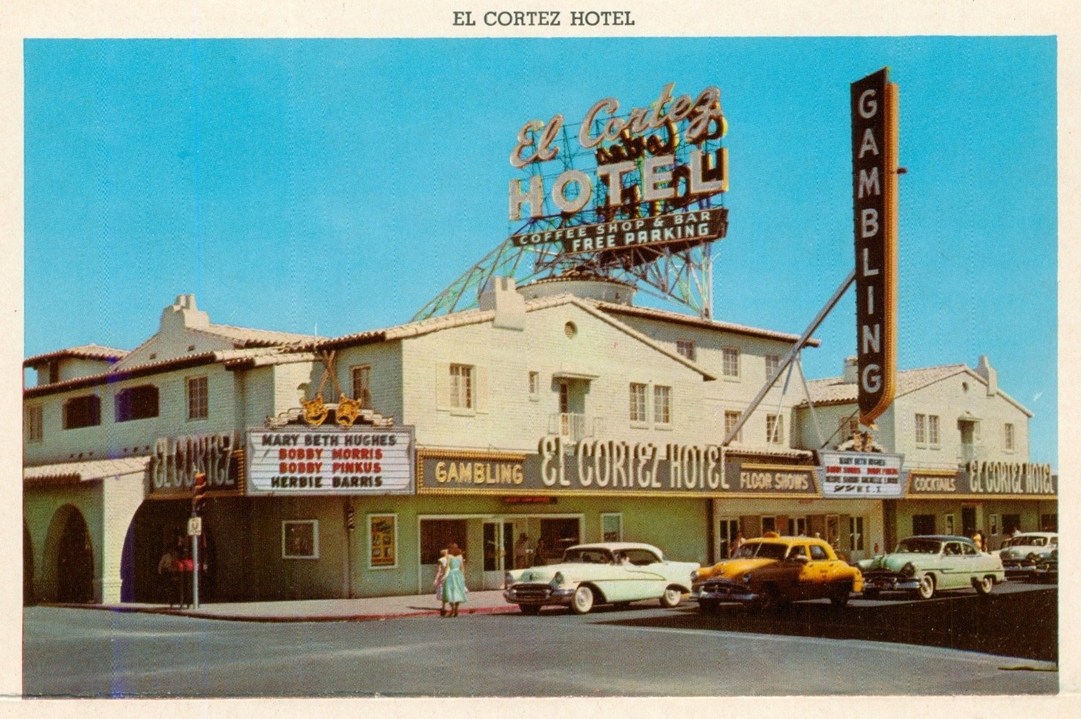 The El Cortez Hotel featuring a large neon sign, with a marquee displaying entertainers' names and advertisements for gambling and cocktails, set against a blue sky.