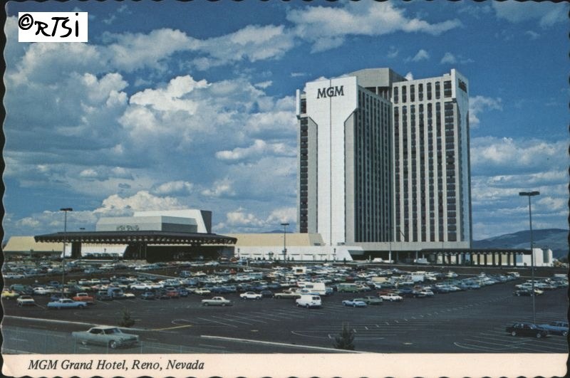 MGM Grand Hotel in Reno, Nevada, featuring a large parking lot filled with cars and a backdrop of blue skies with clouds.