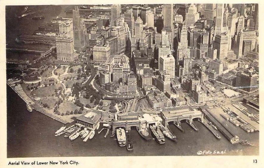 Aerial view of Lower New York City showcasing skyscrapers, parks, and the waterfront with boats docked.