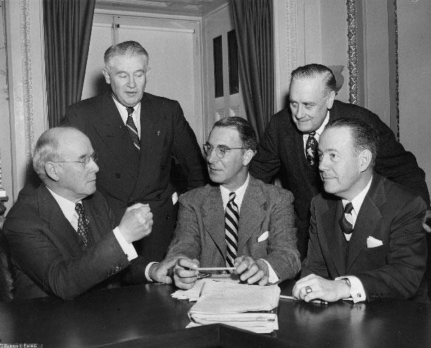 Five members of the United States Senate Kefauver Committee gathered around a desk.