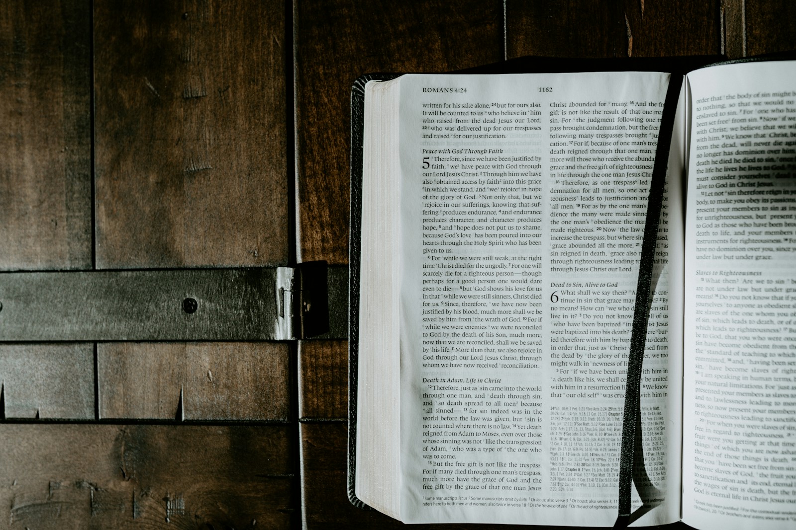 Open Bible with a ribbon bookmark on a rustic wood surface