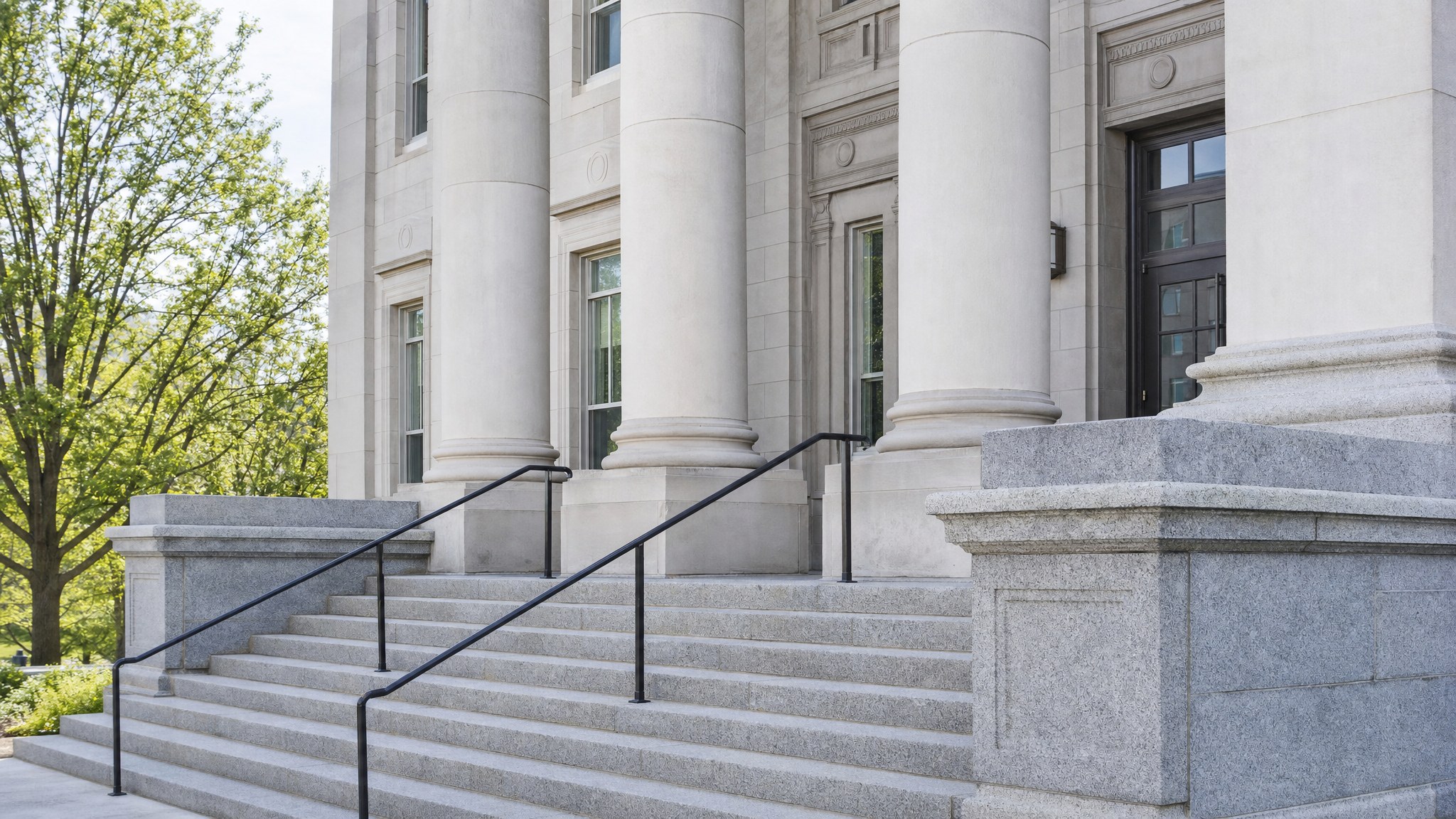 County courthouse entrance with stone columns and steps
