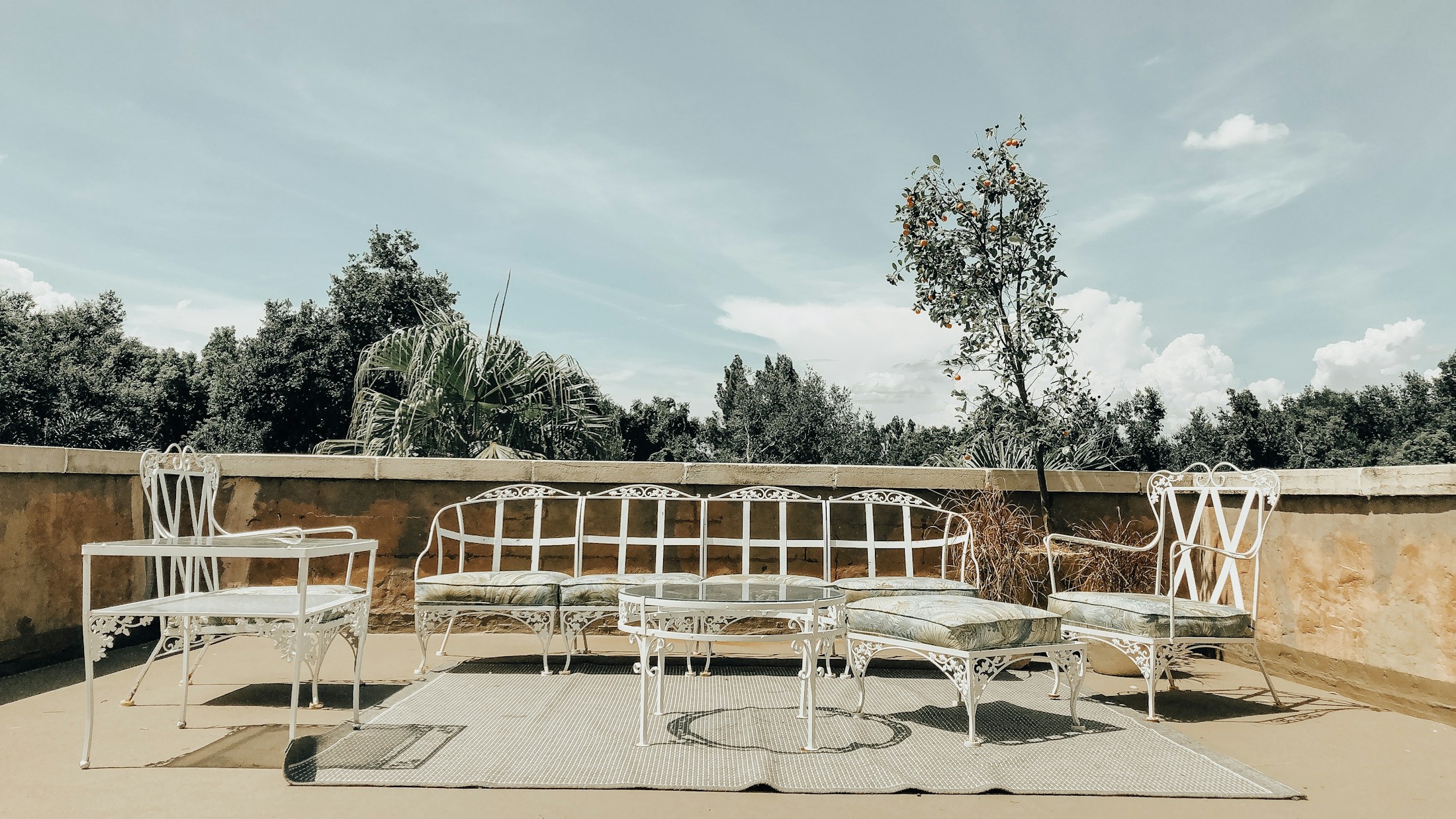 White metal outdoor furniture arranged on a sunny terrace