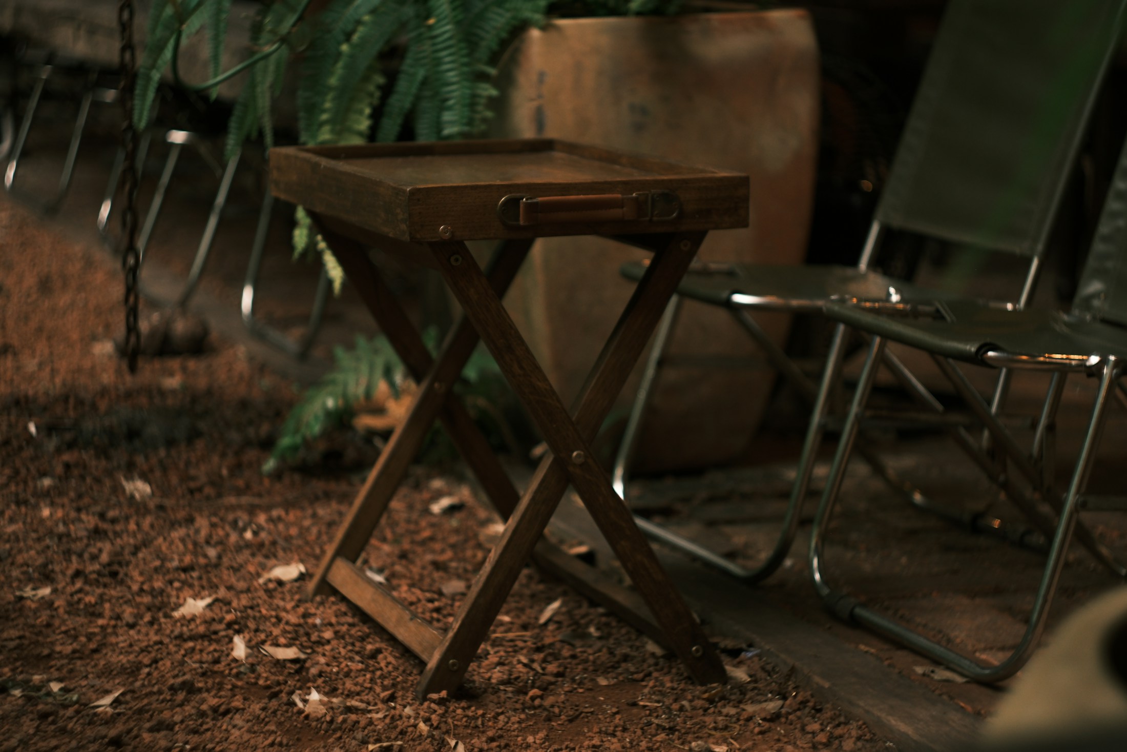 Outdoor folding furniture stored beneath leafy shade