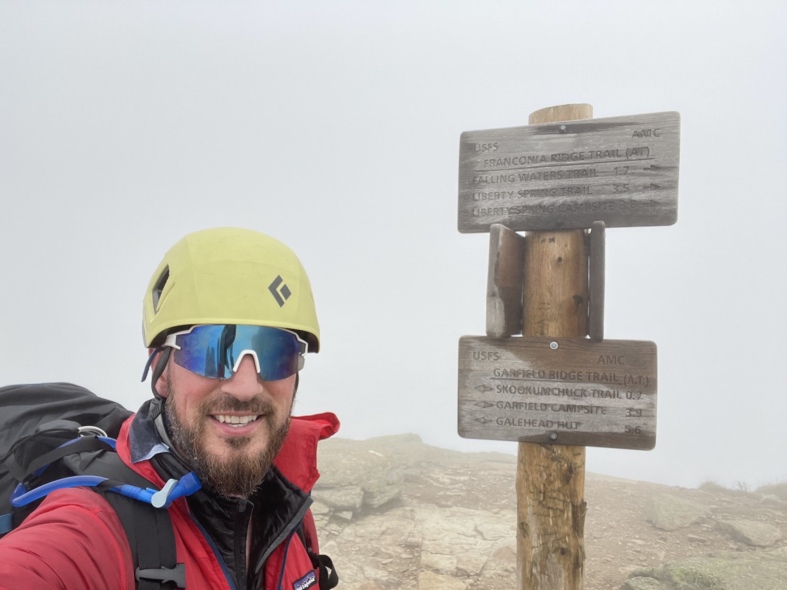 Brad Powell wearing a climbing helmet at a mountain summit