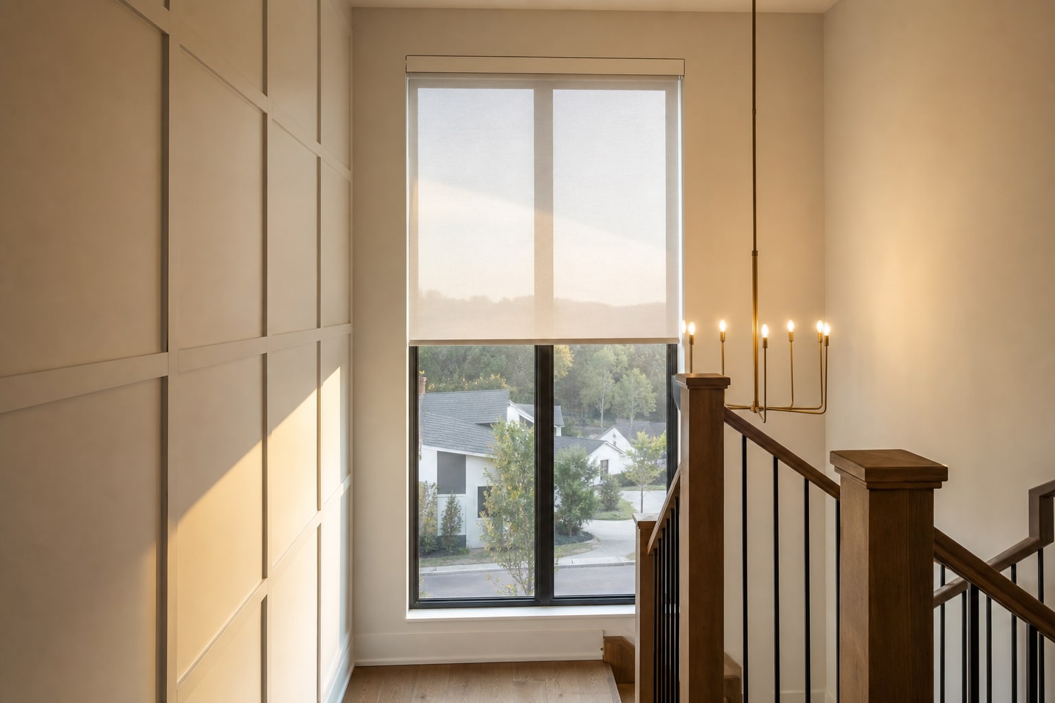 Motorized solar shade covering a tall stairwell window