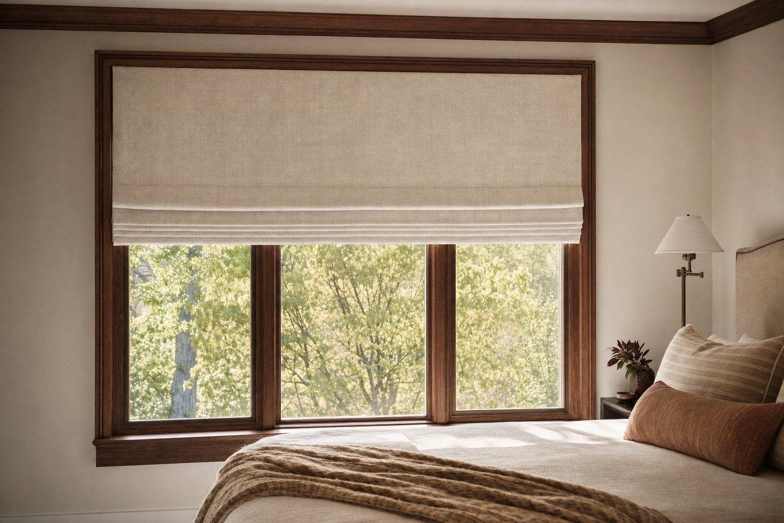 Tailored linen Roman shade above a wood-trim bedroom window