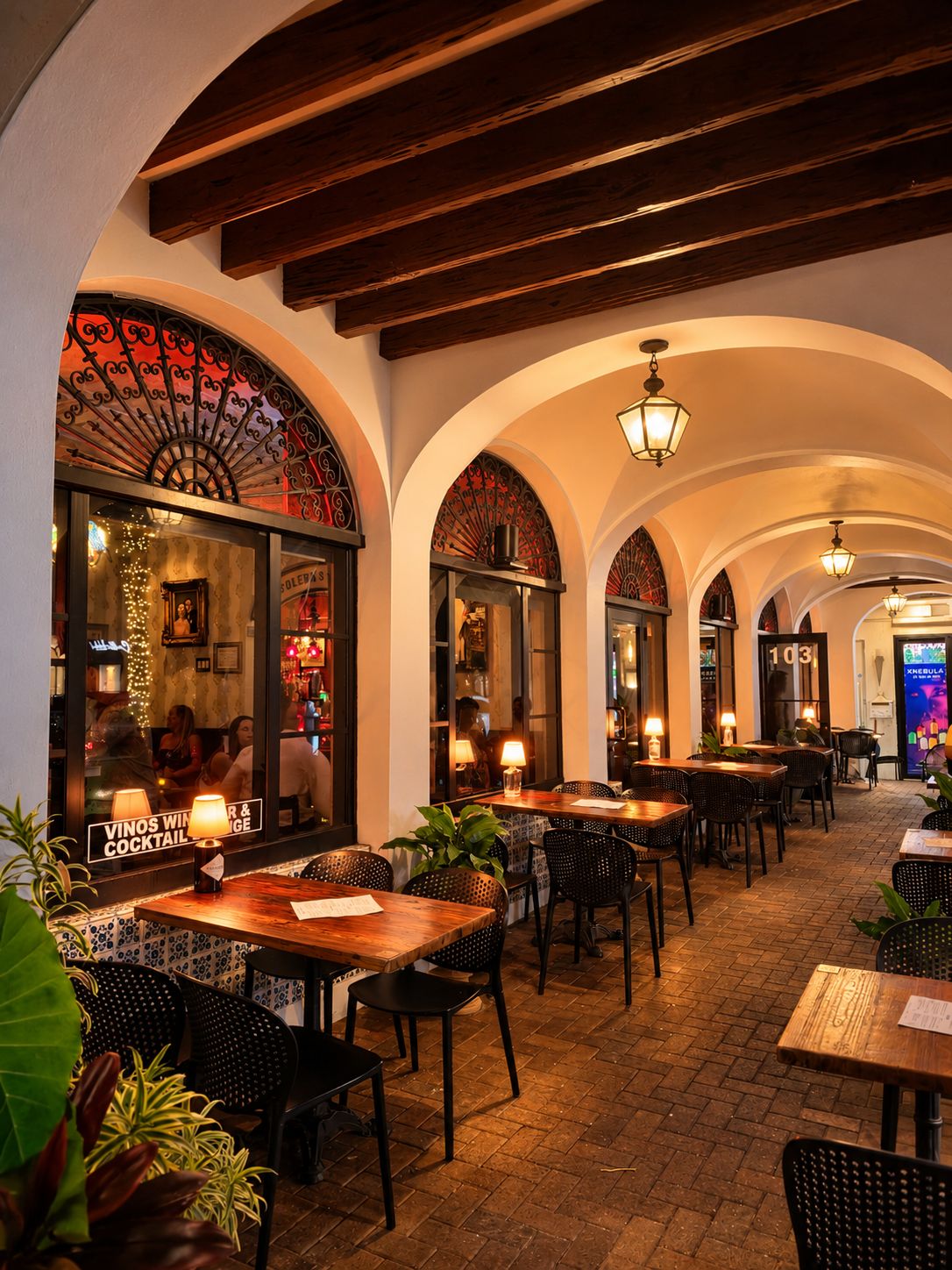 Lamp-lit patio seating beneath the arches at Vinos on Las Olas