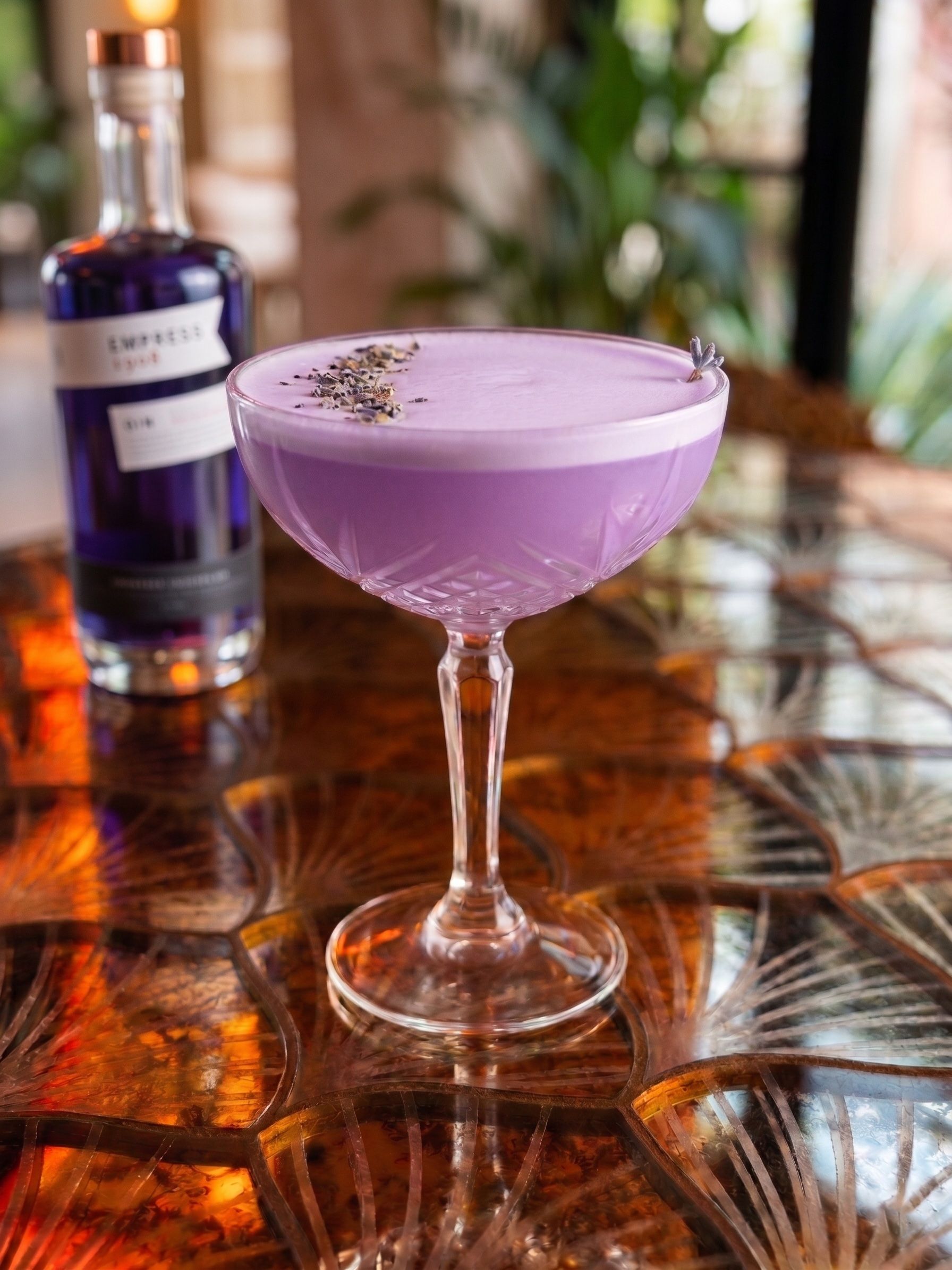 A purple cocktail in a coupe glass at Napoleon’s Parlour