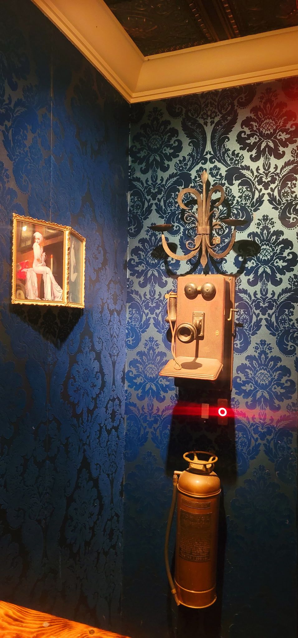 Vintage wall telephone and decorative wallpaper at Sidecar Speakeasy
