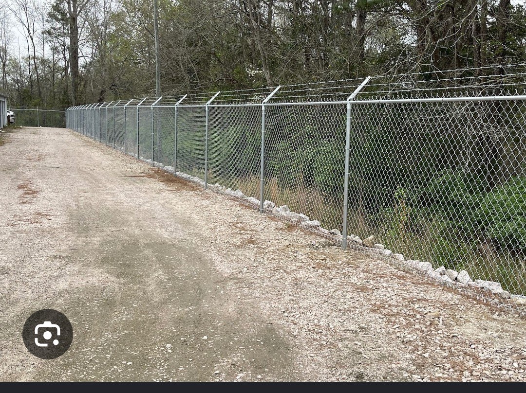 Long commercial security fence topped with barbed wire