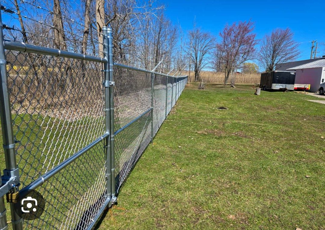 Commercial chain-link gate and perimeter fence beside a business property