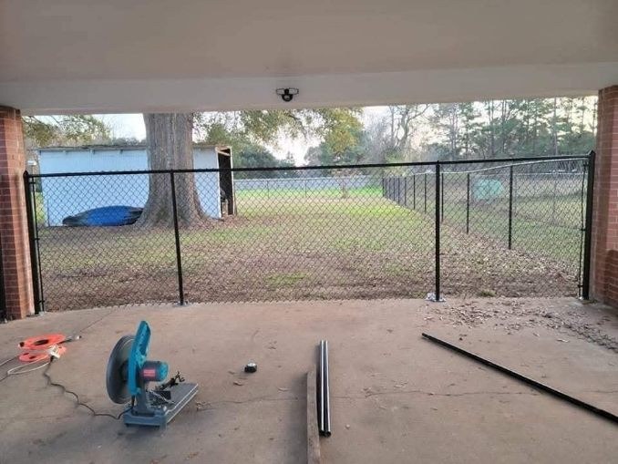 Black chain-link fence enclosing a covered patio