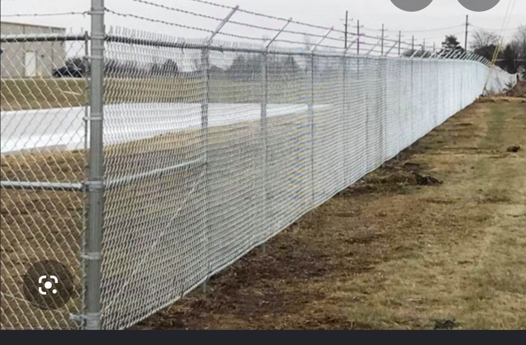 Long galvanized chain-link security fence with angled top rail