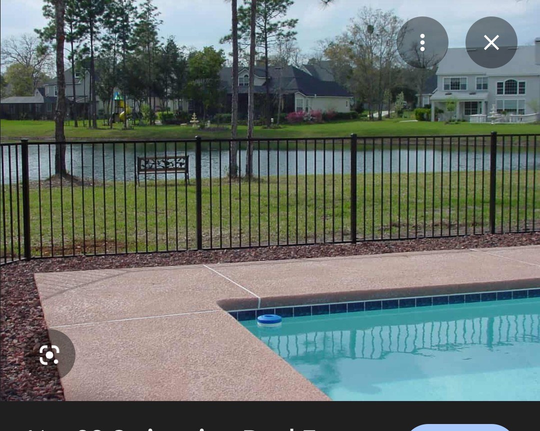 Black aluminum pool fence along a waterfront yard