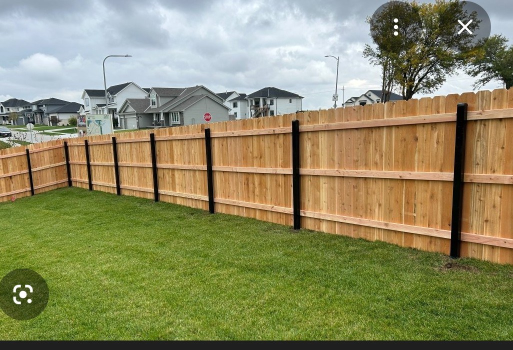 Wood privacy fence with black steel posts installed by Vickers Fence
