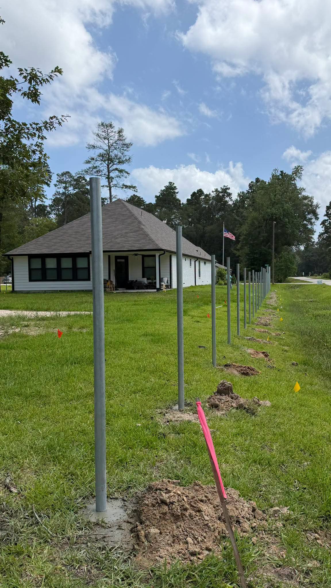 Steel fence posts set in a straight line beside a home