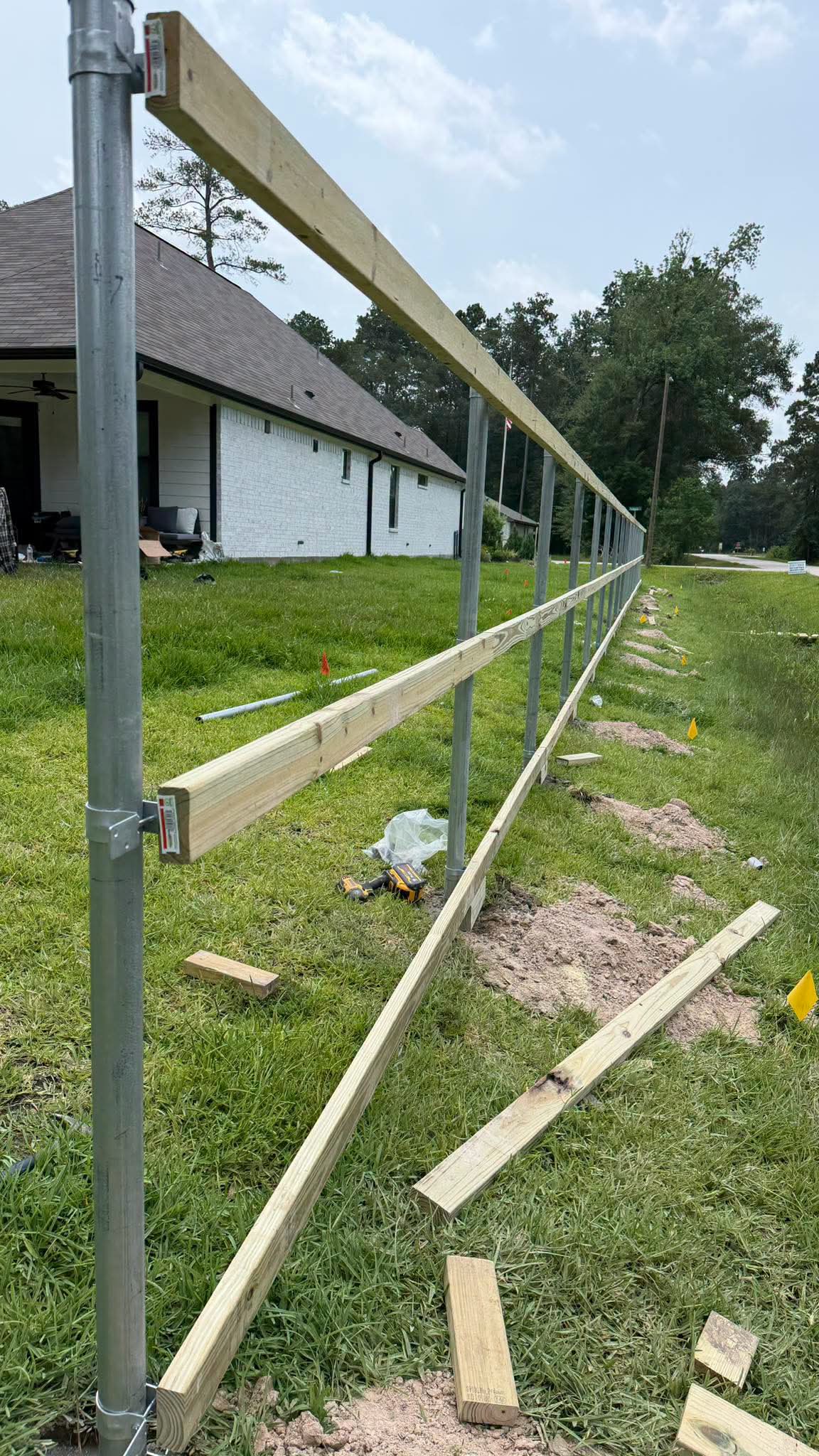 Wood rails installed between steel posts on a new fence project