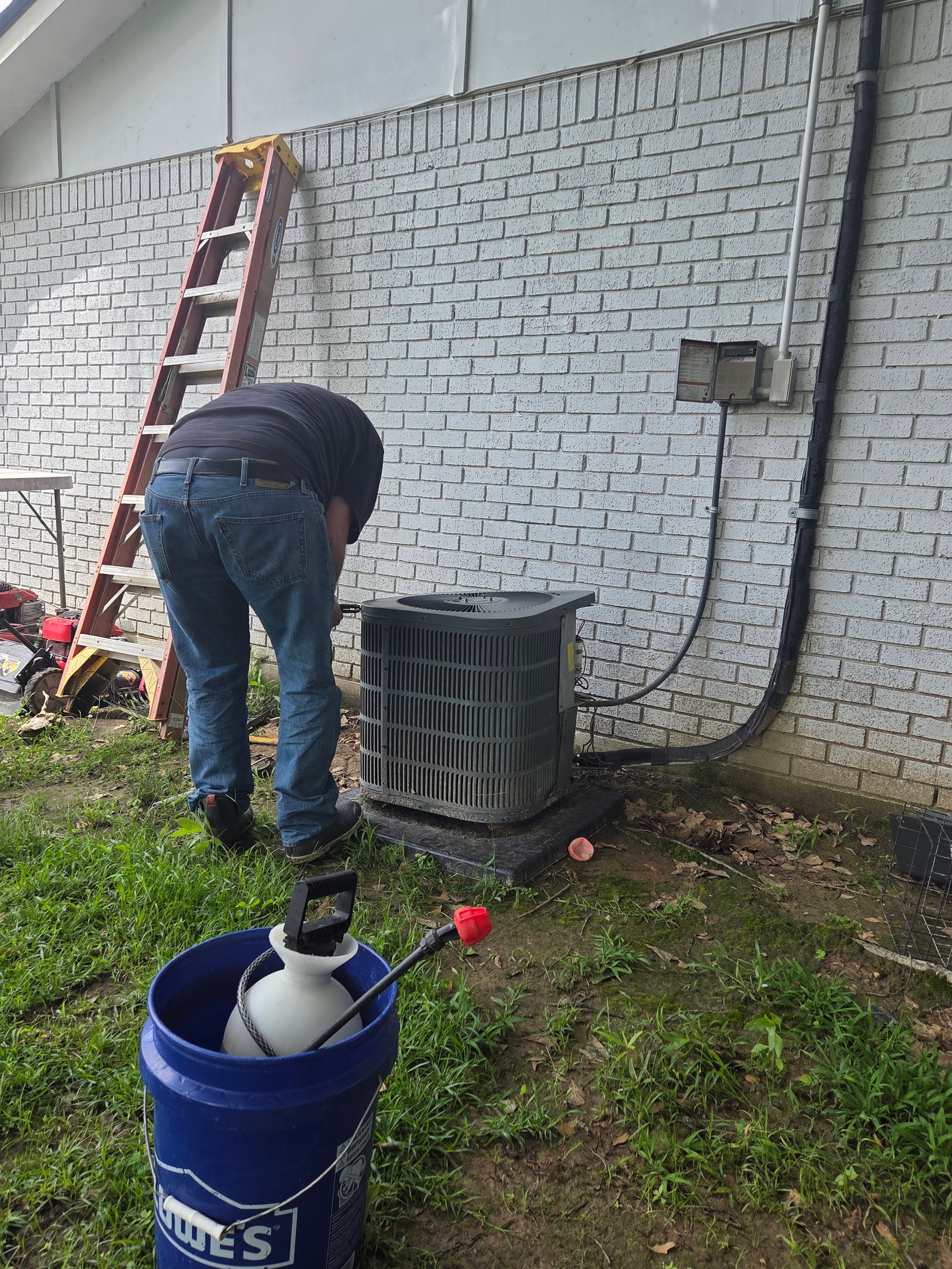 Technician servicing an outdoor air conditioning unit