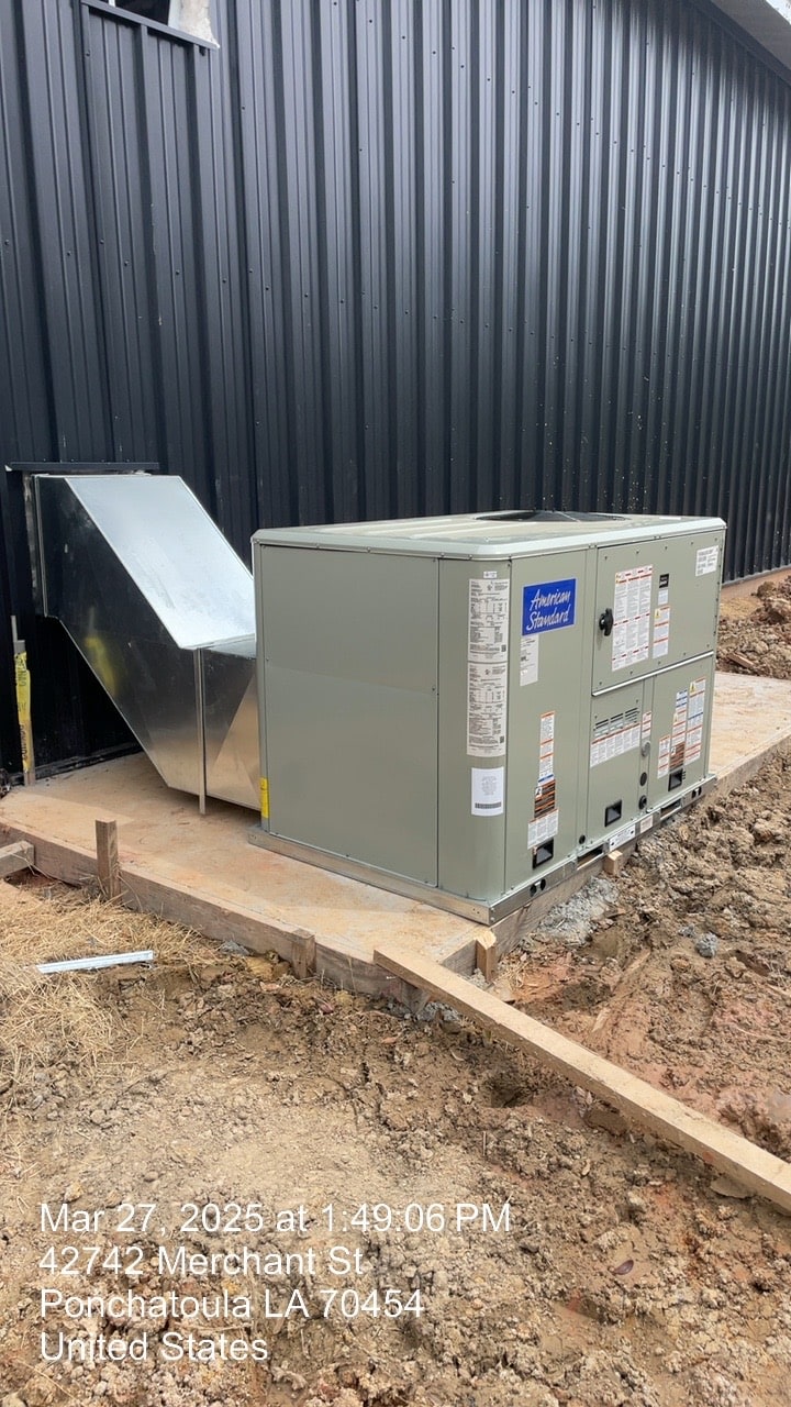 New outdoor HVAC unit and ductwork installed at a metal building