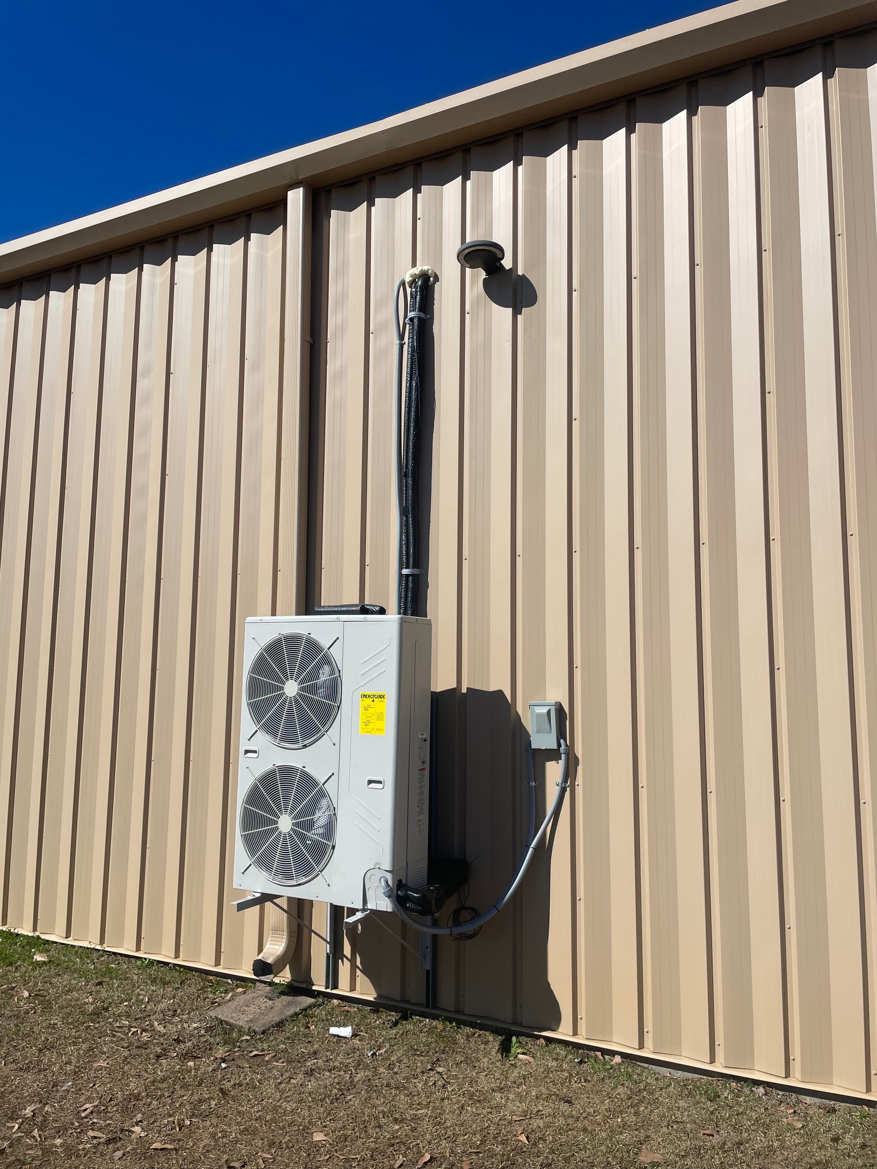 Ductless mini-split outdoor unit installed on a metal exterior wall