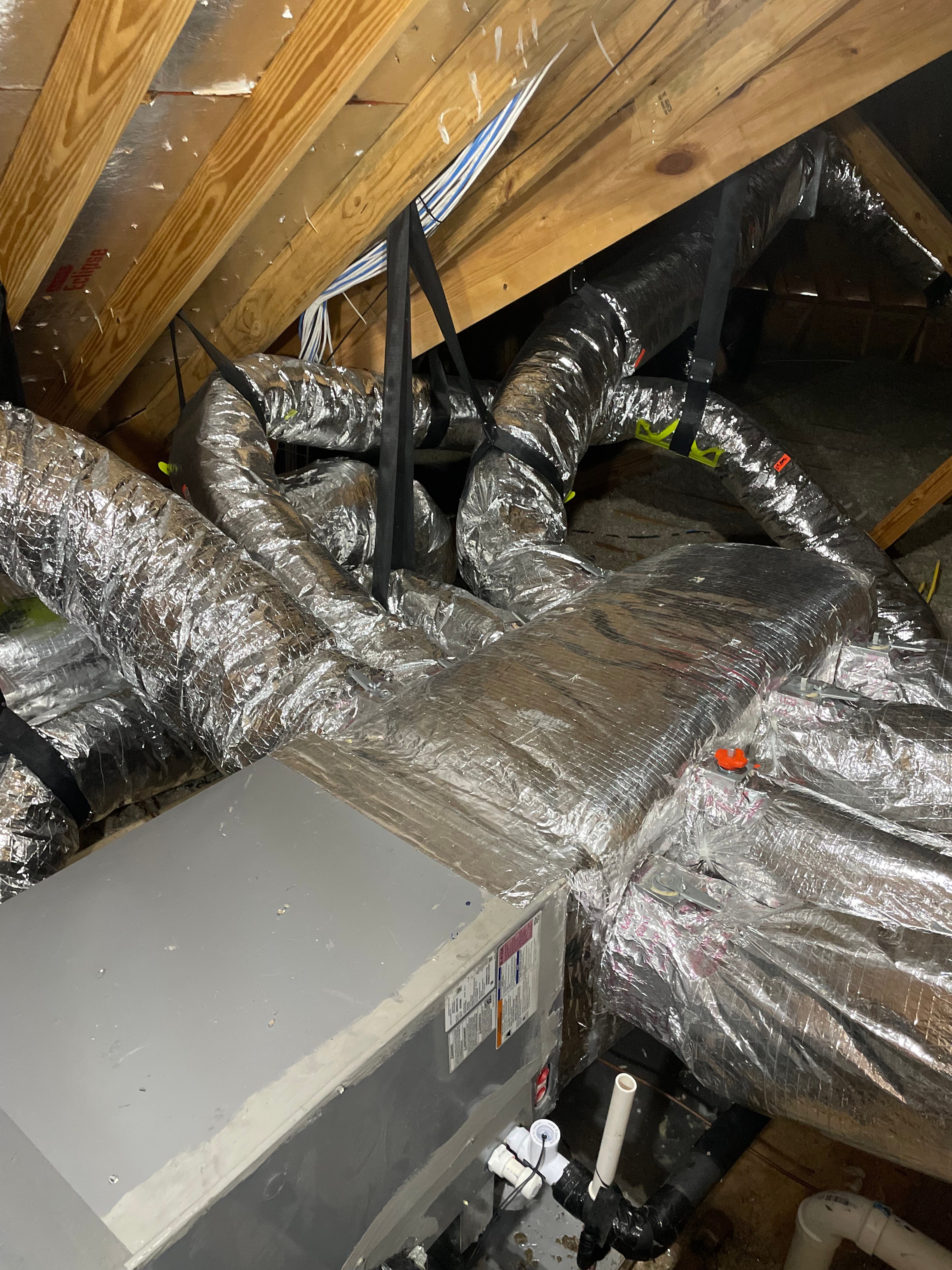 Residential attic with insulated HVAC ductwork