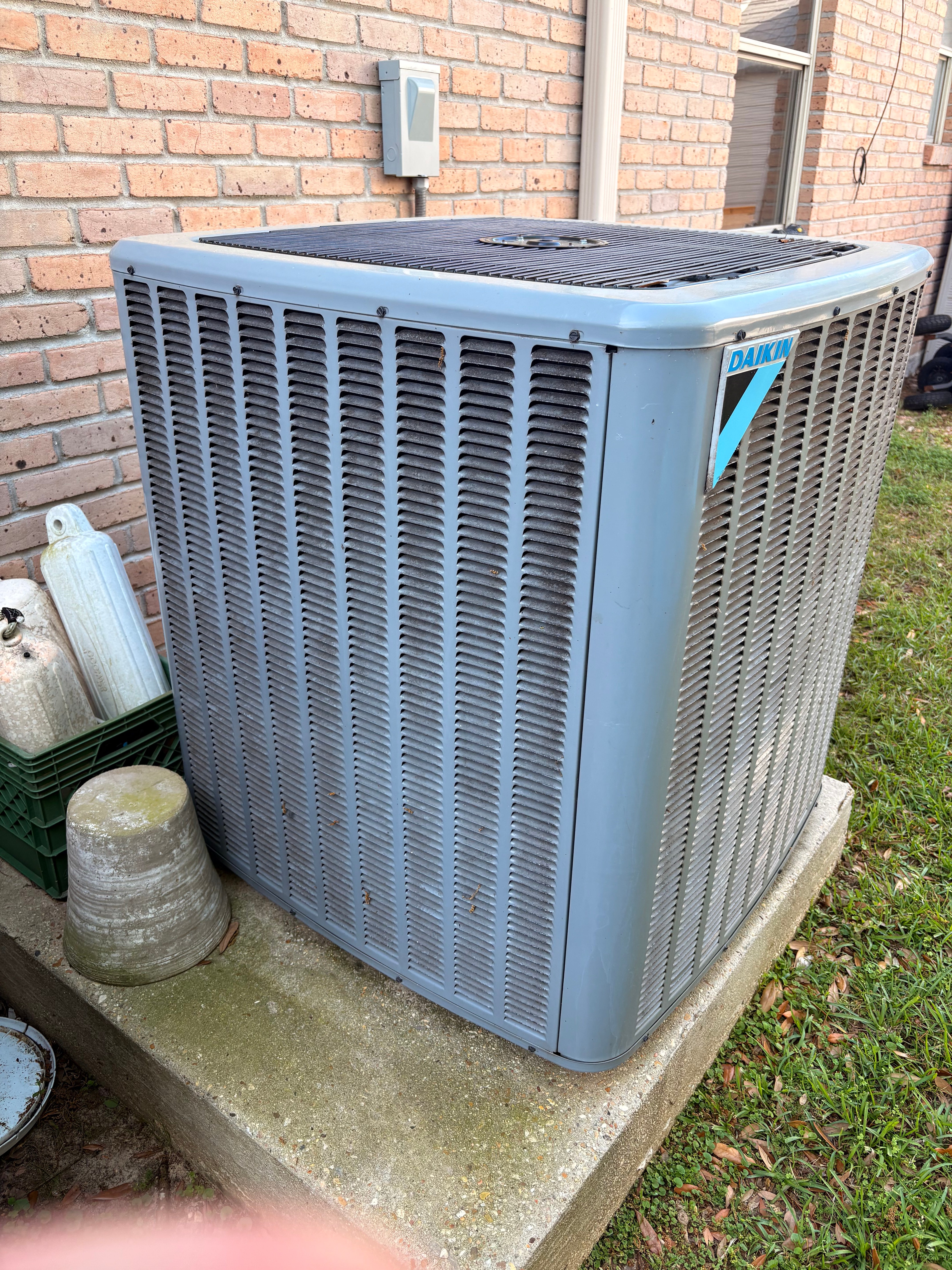 Outdoor air conditioning condenser installed beside a home
