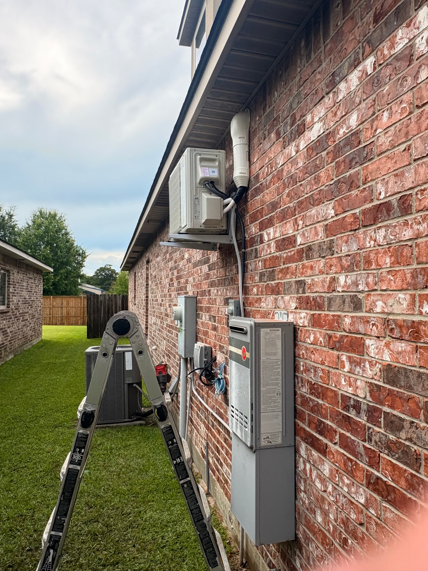 Residential HVAC system beside a brick home