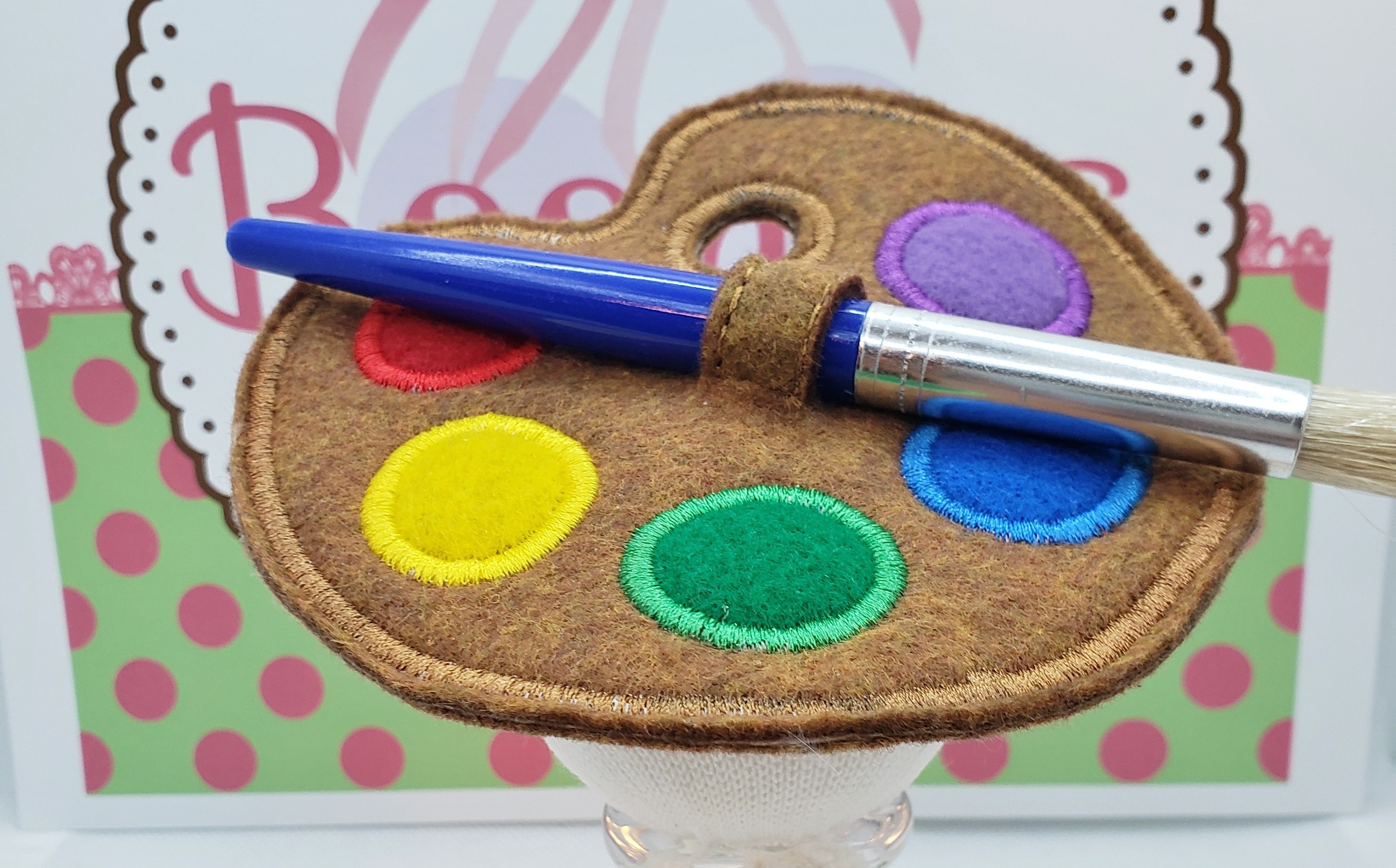 Palette-shaped fascinator with colorful appliqué and a paintbrush