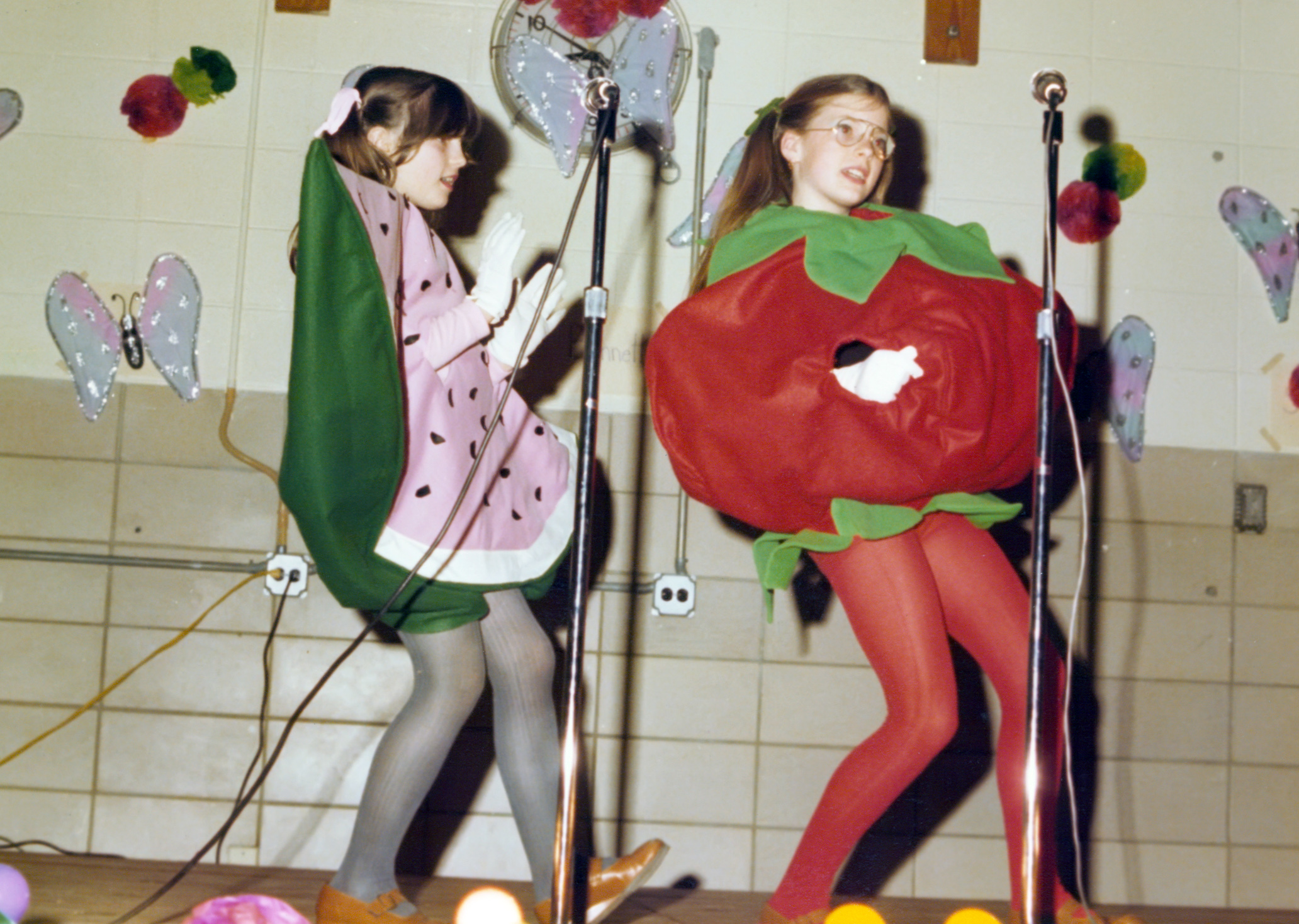 Children in colorful costumes performing on stage