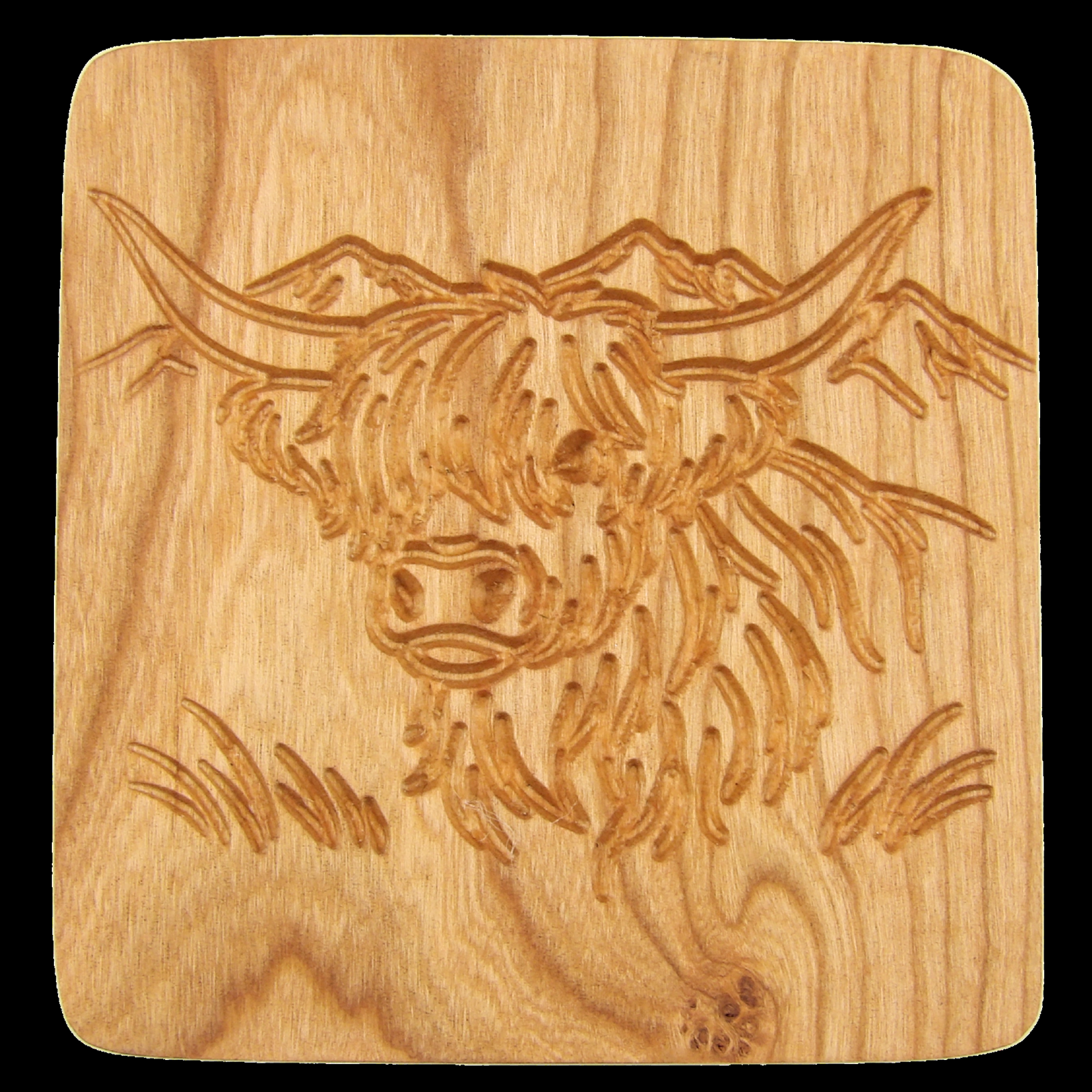 Engraved hardwood drink coaster with a cow design