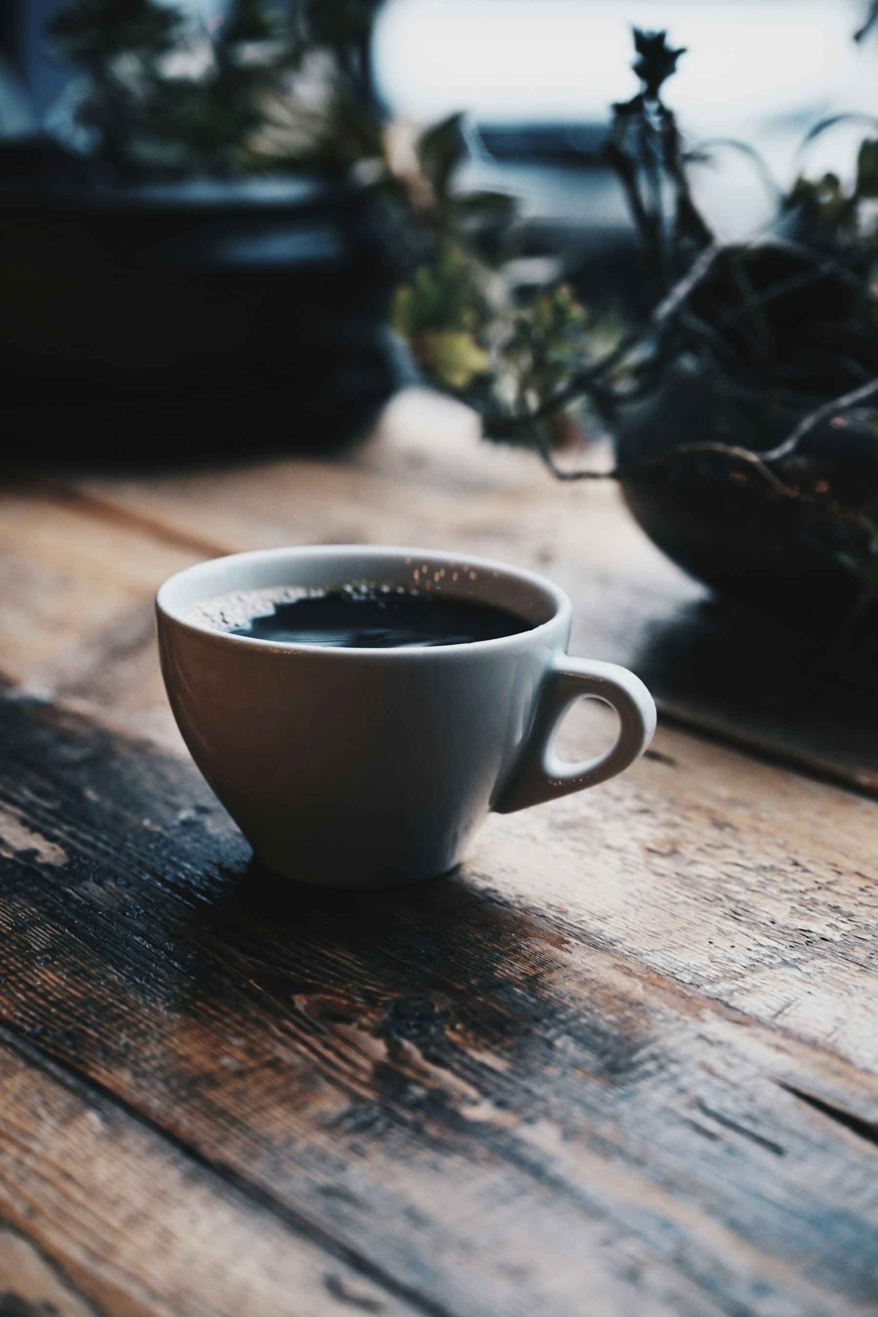 Black coffee in a ceramic cup on a wooden table