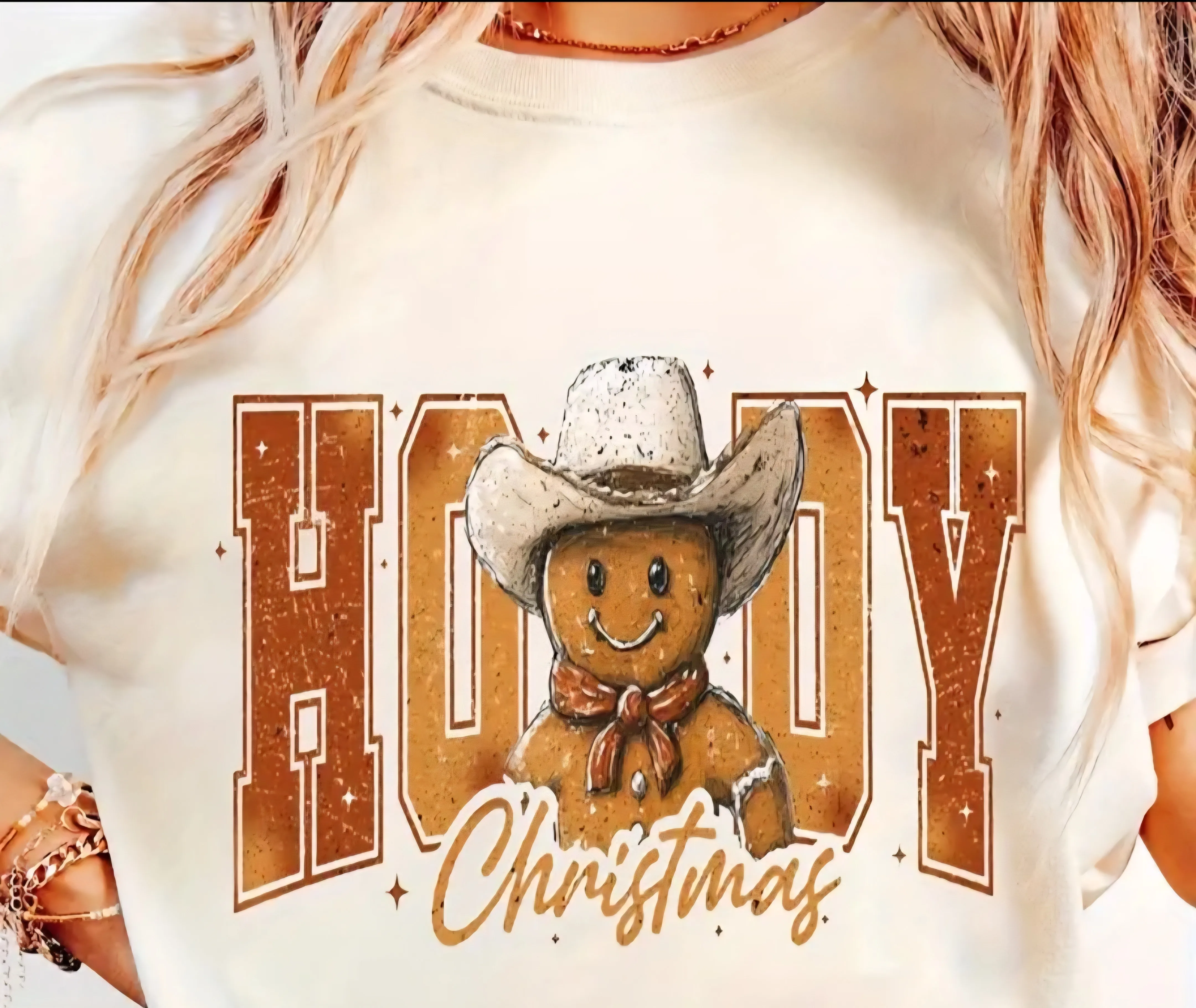 Gingerbread cowboy wearing a hat with the text "HOODY Christmas" on a tee.