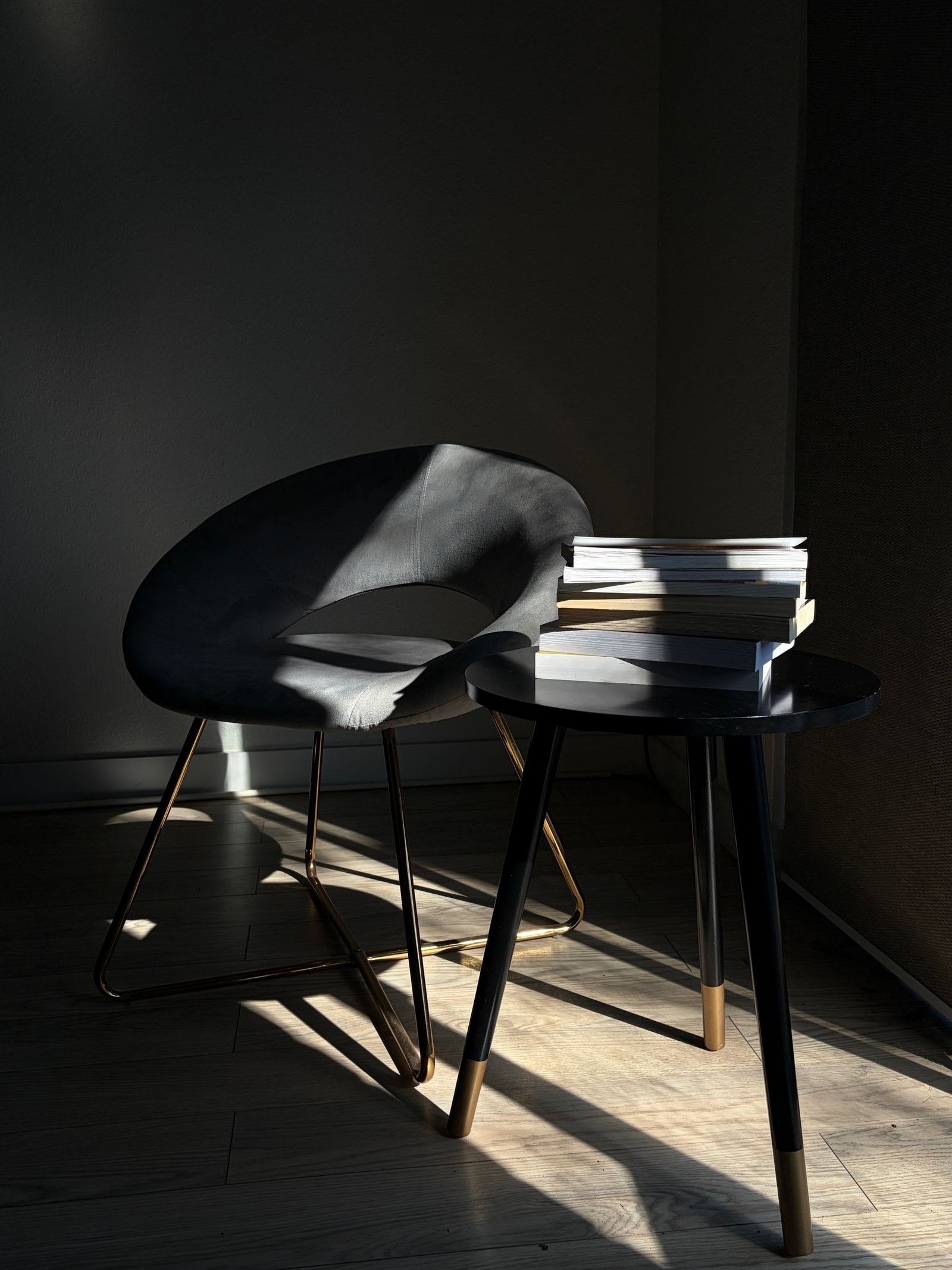 A quiet chair and books in a sunlit room