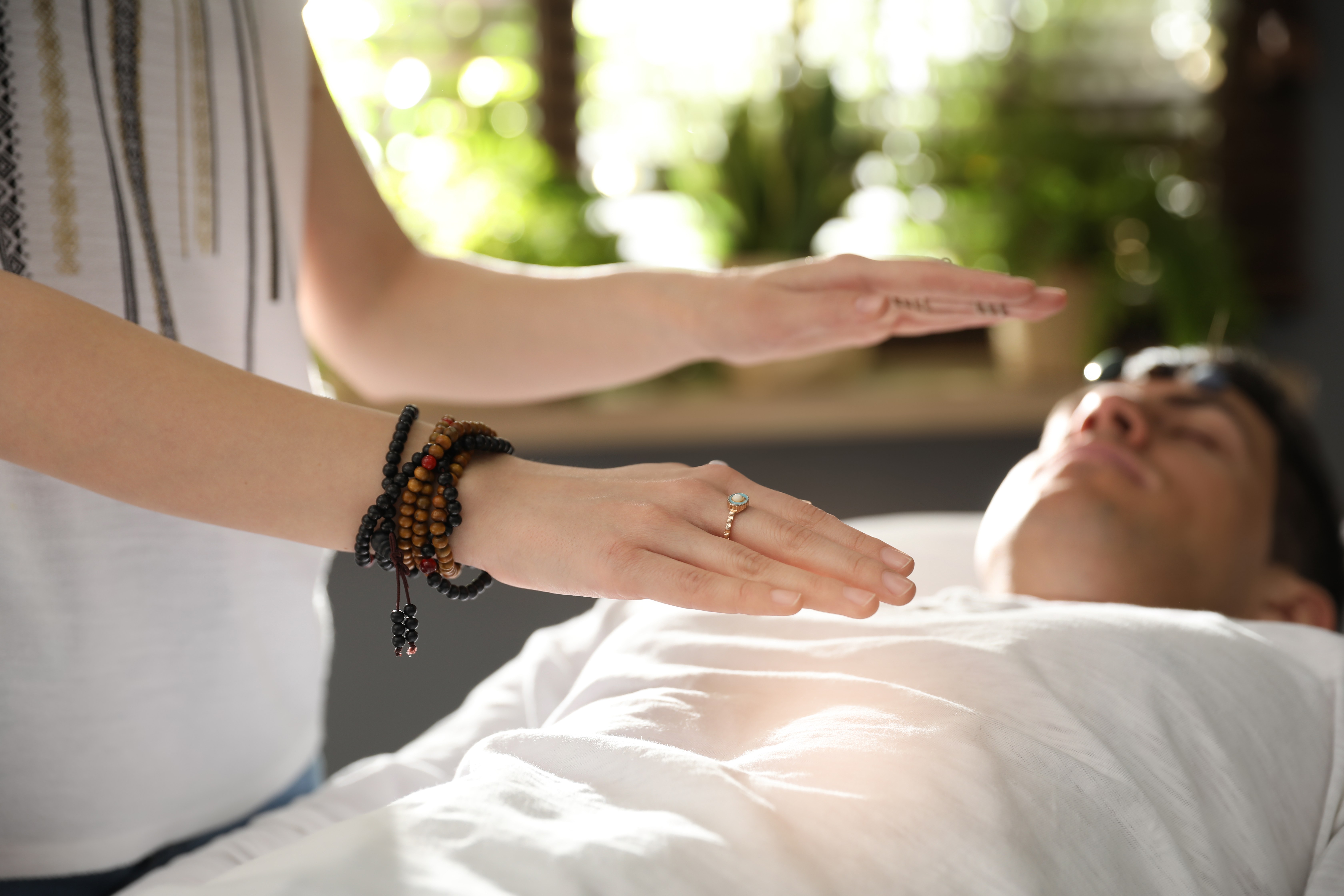 Reiki practitioner offering a hands-off session to a resting client