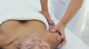 Hands resting gently at the shoulders during a Reiki session