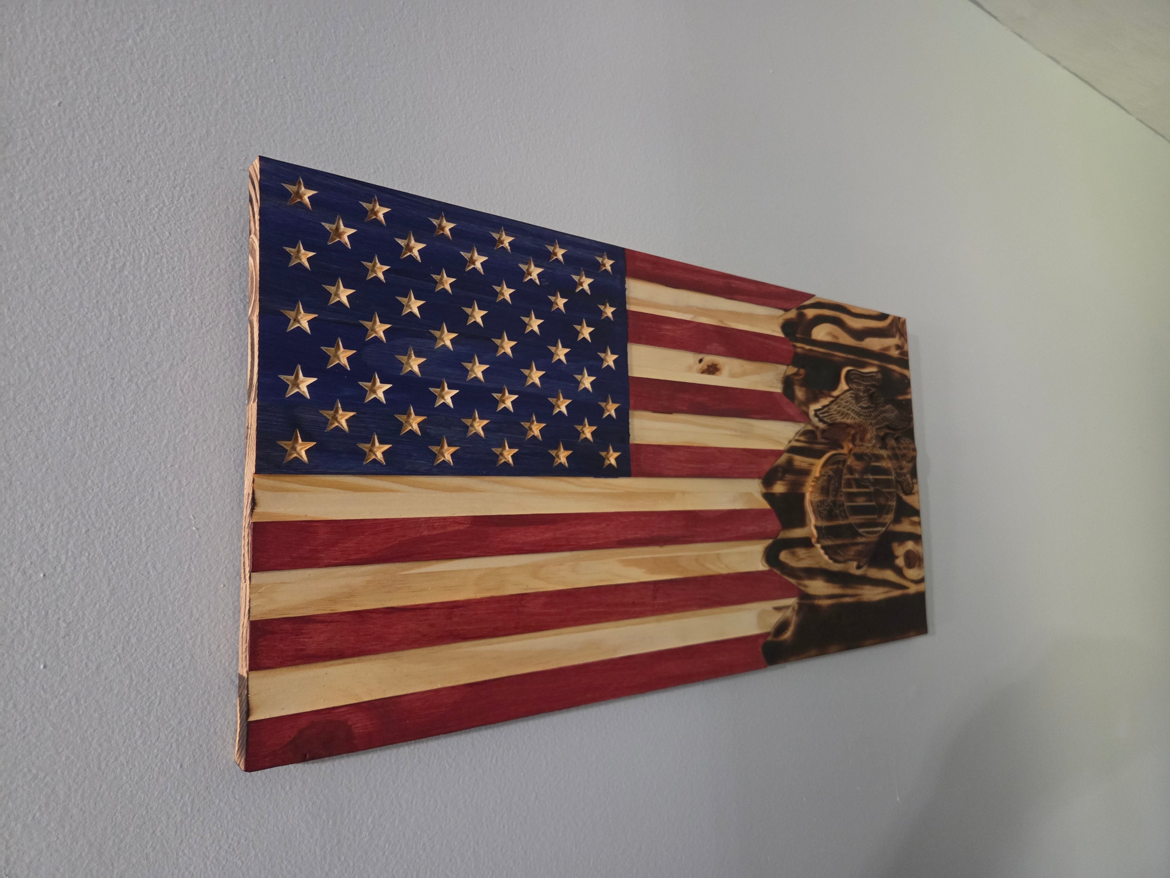 Close detail of a handcrafted Marine Corps wooden flag with carved emblem and stained wood