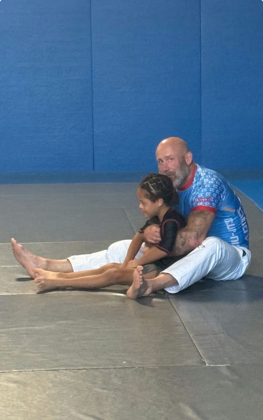 Casey Thom on the Brazilian Jiu-Jitsu mats with a young training partner