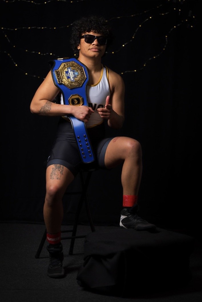 Xochitl Mota-Pettis holding a wrestling championship belt