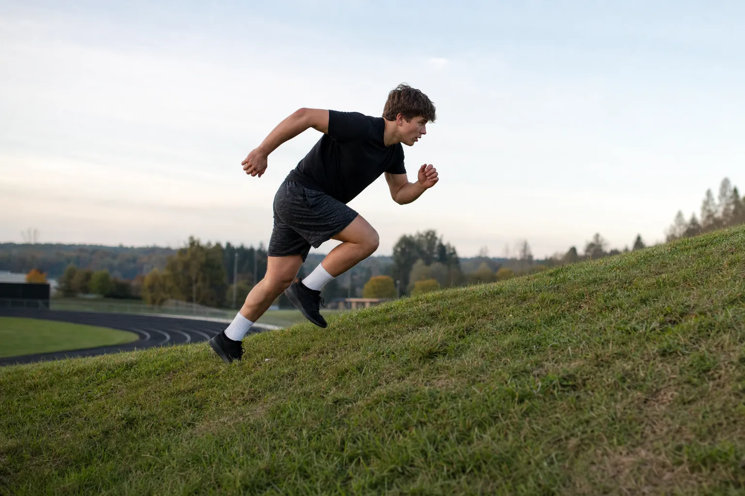 A wrestler sprinting uphill during an interval session