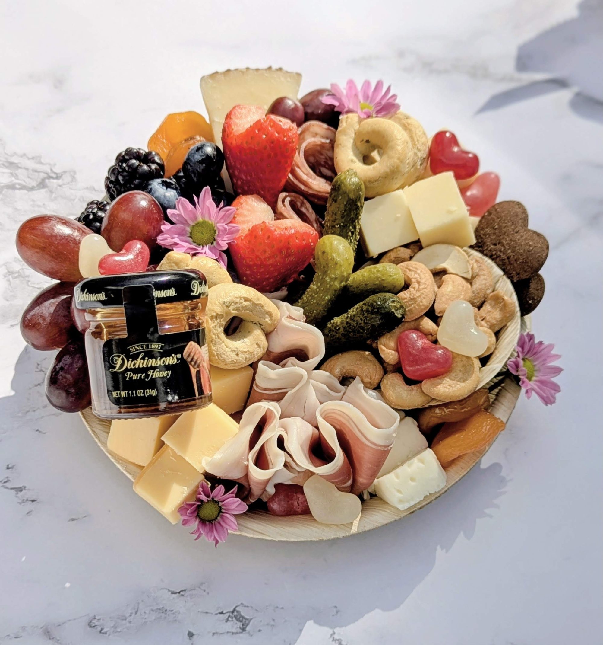 A Yellow House Grazing mini board with cheeses, charcuterie, berries and flowers