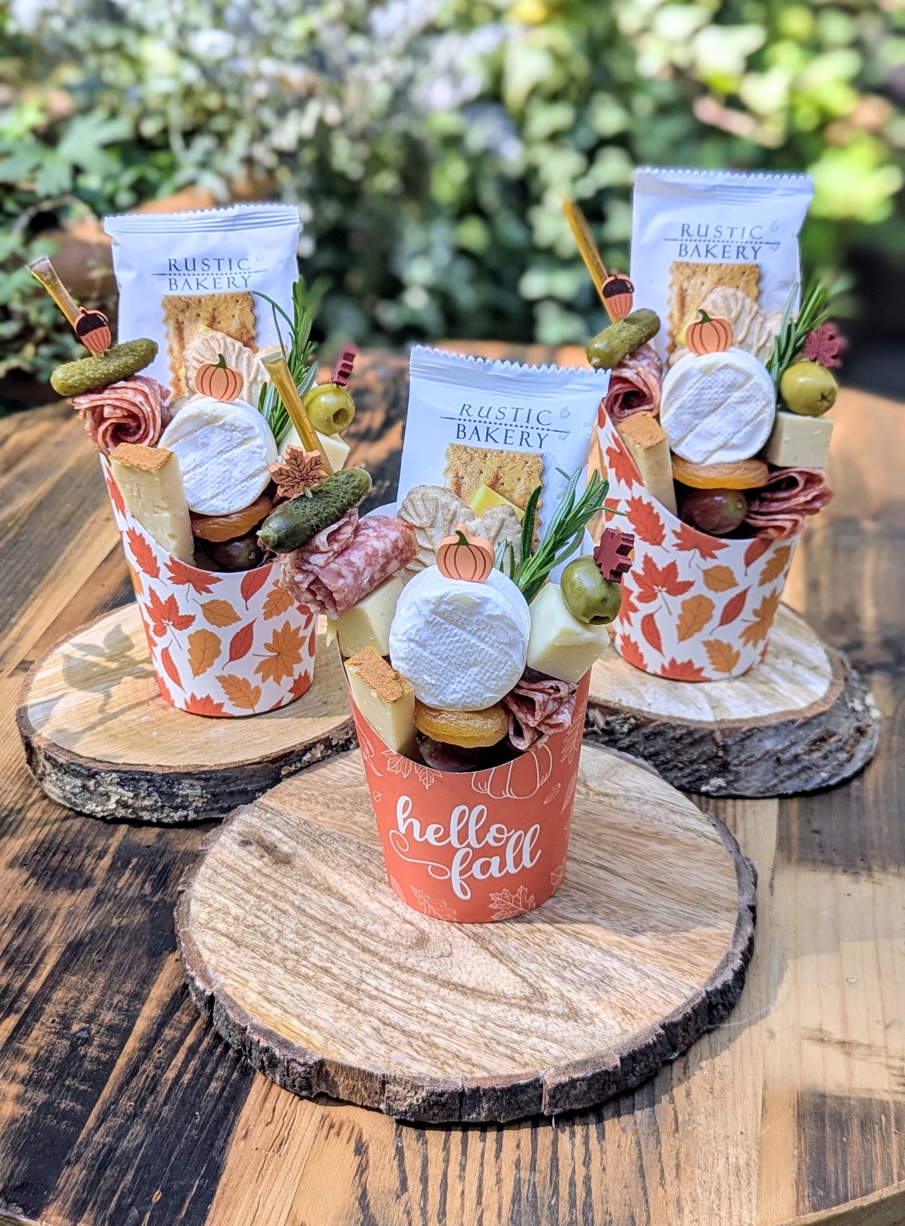 Individual Yellow House Grazing charcuterie cups arranged outdoors