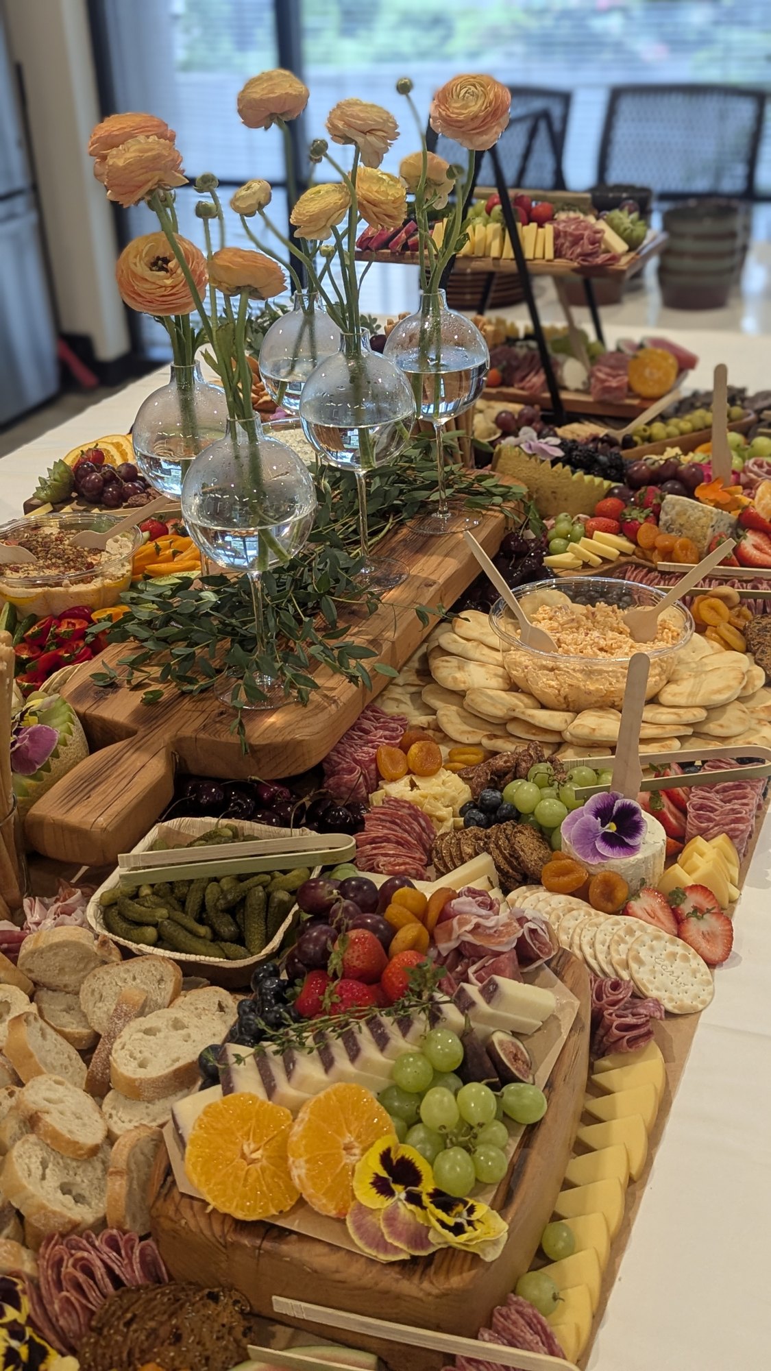 Grazing table with artisan cheeses, charcuterie, fruit and yellow flowers