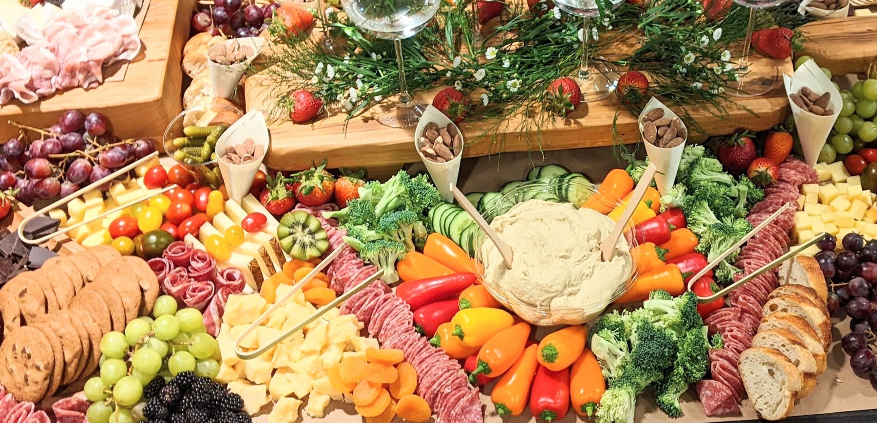 Abundant grazing spread with colorful vegetables, cheeses, fruit and dips